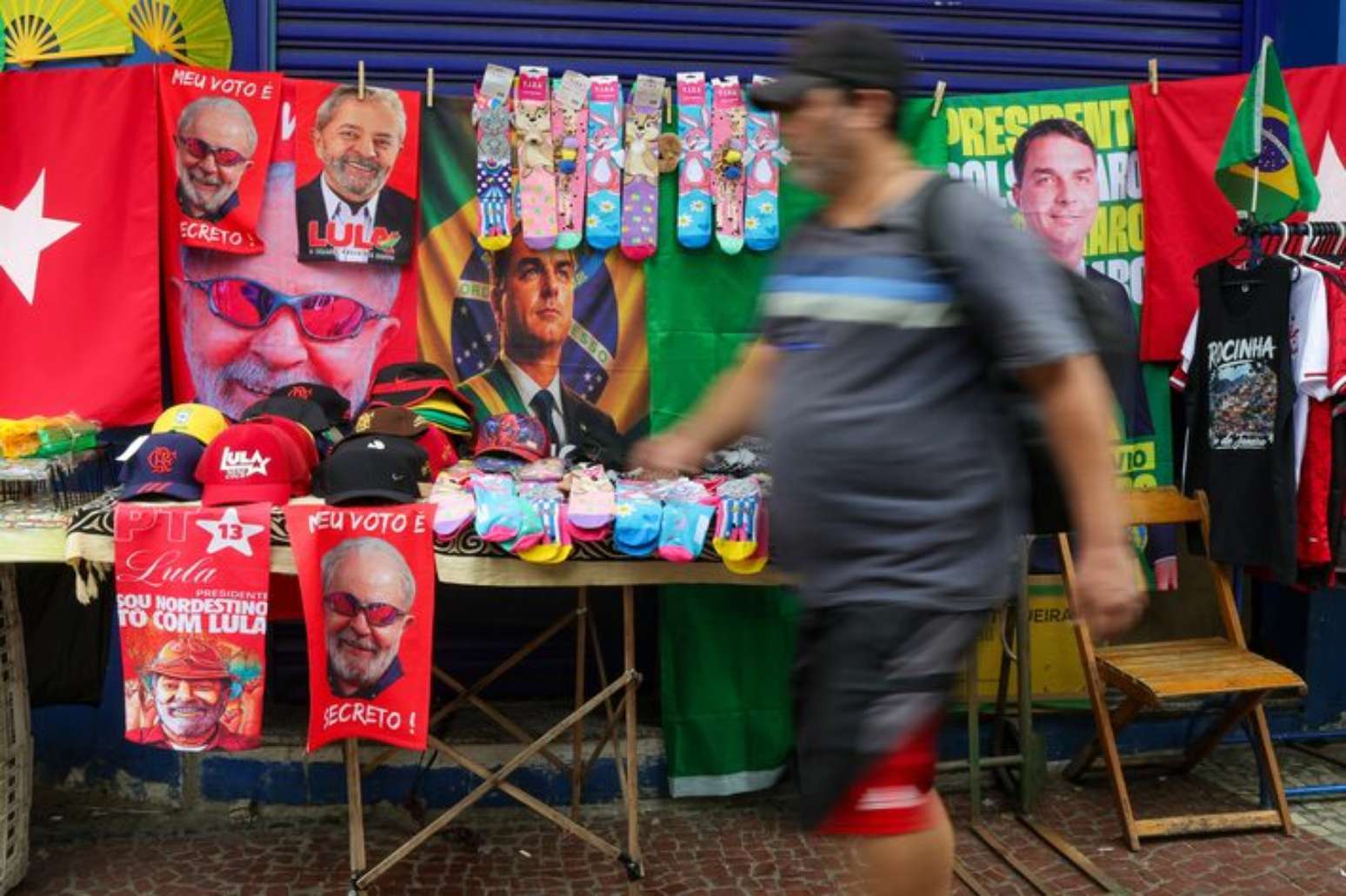 Ambulante com toalhas de Lula e Flávio Bolsonaro a venda na rua Siqueira Campos, em Copacabana, zona sul do Rio de Janeiro.
