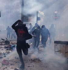 Manifestante corre durante uma manifestação contra o alto custo de vida, em Paris, neste sábado (17), no âmbito de uma convocação nacional que reuniu diferentes grupos mobilizados pelo descontentamento social, entre eles ex-integrantes dos coletes amarelos, estudantes do ensino médio e universitários, ativistas ambientais e agricultores. Foto: AFP - KIRAN RIDLEY / RFI